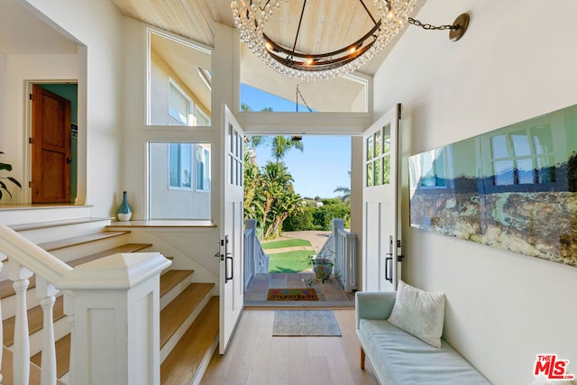 entryway featuring a chandelier, light hardwood / wood-style flooring, and a high ceiling