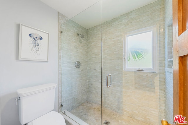 bathroom with an enclosed shower and toilet