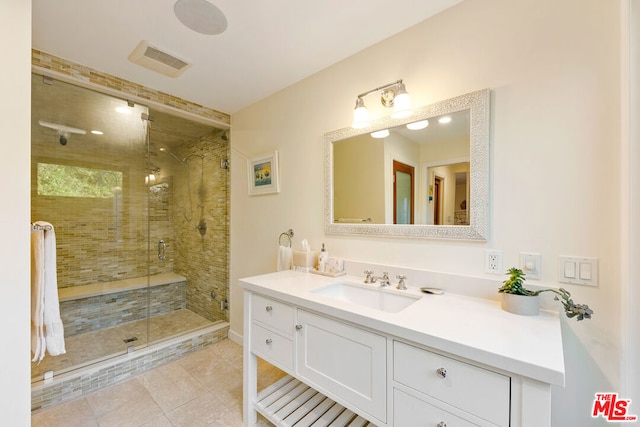 bathroom with vanity, tile patterned floors, and a shower with door