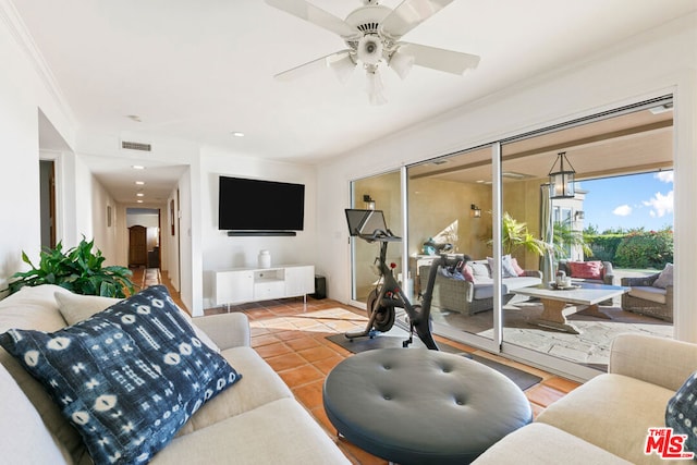 exercise room featuring crown molding, ceiling fan, and tile patterned flooring