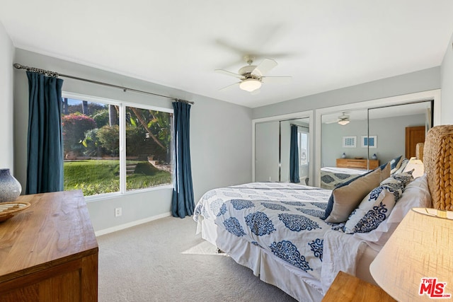 bedroom with light carpet, two closets, and ceiling fan