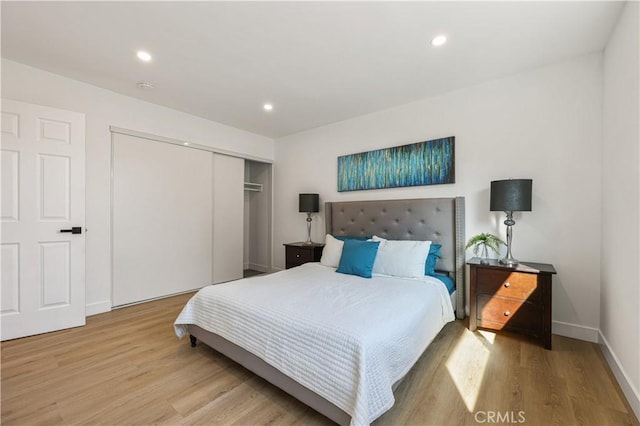 bedroom with light hardwood / wood-style flooring and a closet