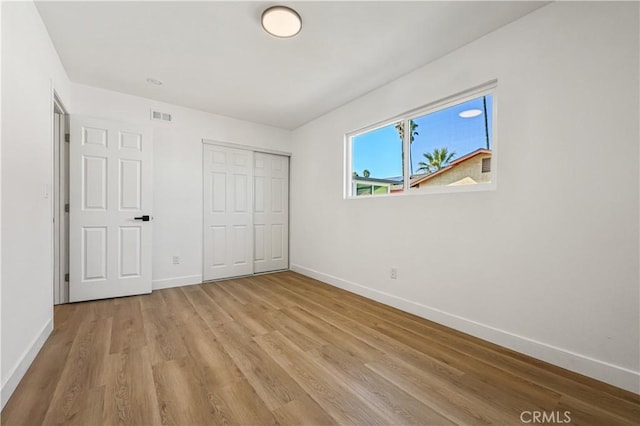 unfurnished bedroom featuring a closet and light wood-type flooring