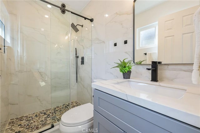 bathroom featuring a shower with shower door, tasteful backsplash, tile walls, vanity, and toilet