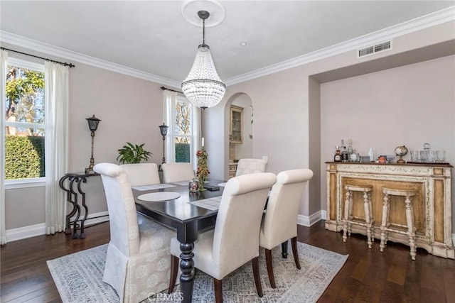 dining area with ornamental molding, an inviting chandelier, dark hardwood / wood-style flooring, and a baseboard radiator