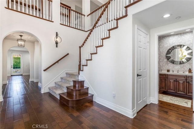 stairs with a high ceiling and wood-type flooring