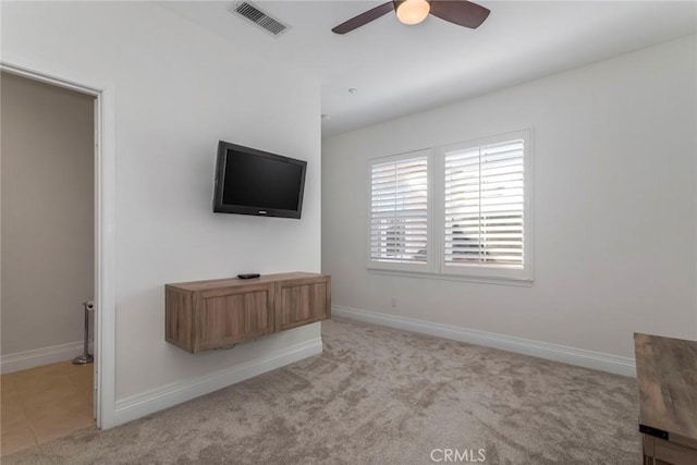 unfurnished living room featuring light carpet and ceiling fan