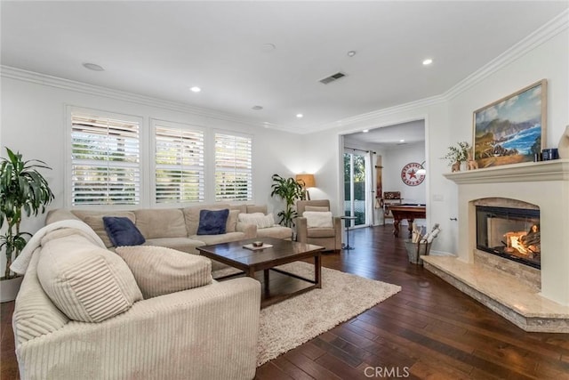 living room with dark wood-type flooring, ornamental molding, and a fireplace