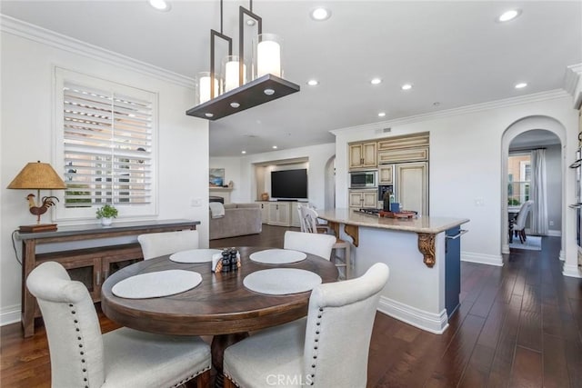 dining space featuring ornamental molding and dark hardwood / wood-style flooring