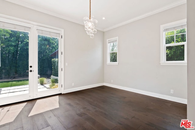 empty room featuring crown molding, dark hardwood / wood-style floors, a chandelier, and french doors