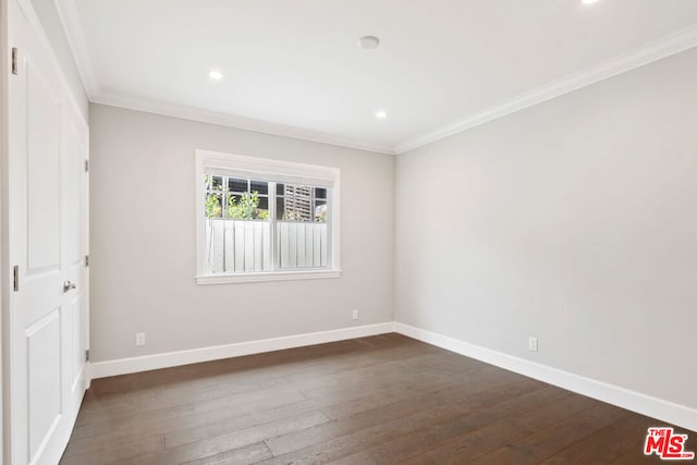 empty room featuring crown molding and dark hardwood / wood-style floors