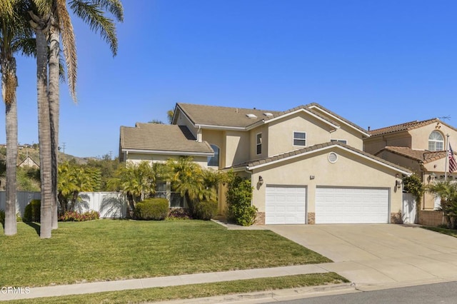 view of front of house with a tile roof, fence, concrete driveway, stucco siding, and a front lawn