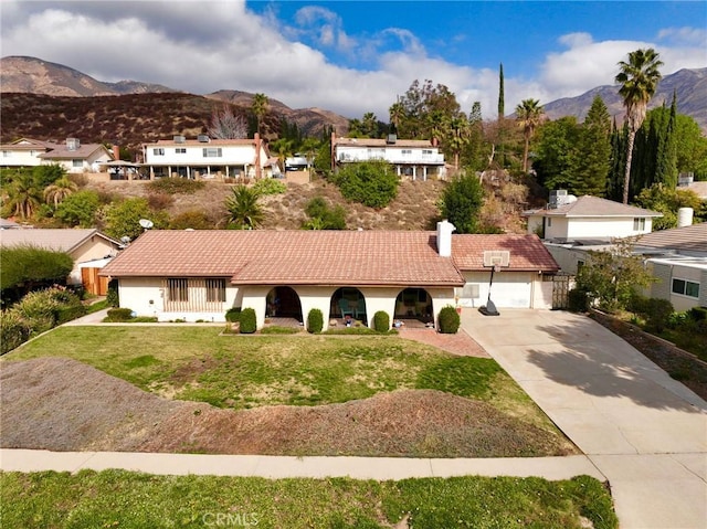 view of front of property featuring a garage, a mountain view, and a front yard