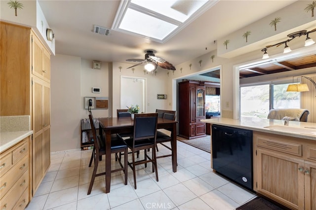 interior space with light tile patterned flooring, ceiling fan, and a skylight