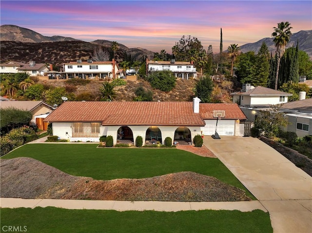 view of front of home with a garage, a mountain view, and a yard