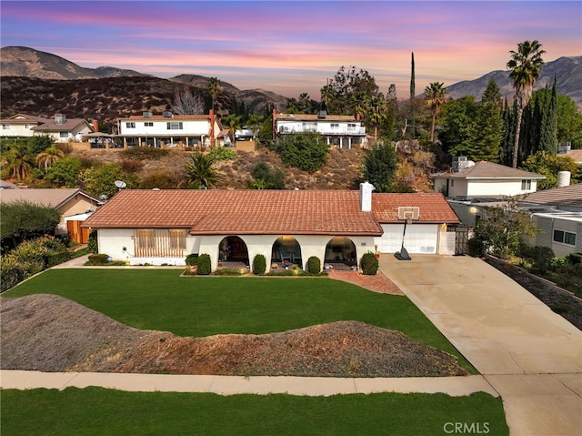 view of front of house featuring a garage, a mountain view, and a yard