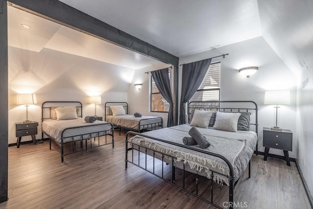 bedroom featuring hardwood / wood-style flooring and beamed ceiling