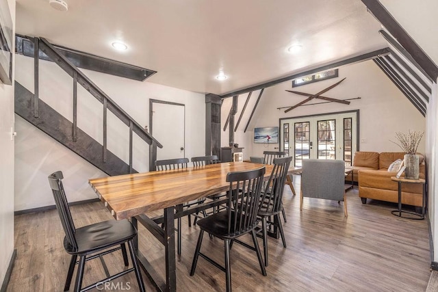 dining area with french doors, wood-type flooring, and vaulted ceiling