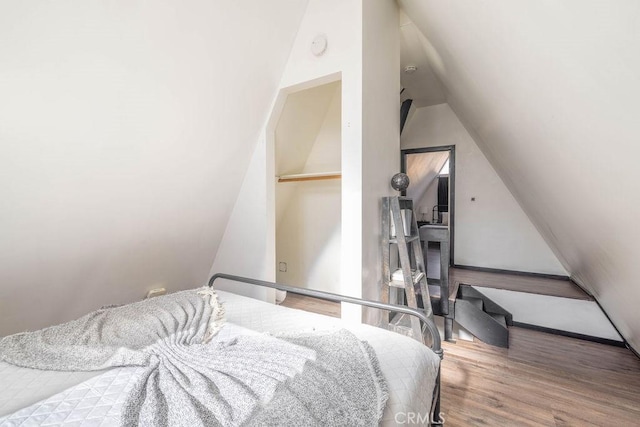 bedroom featuring hardwood / wood-style floors and vaulted ceiling