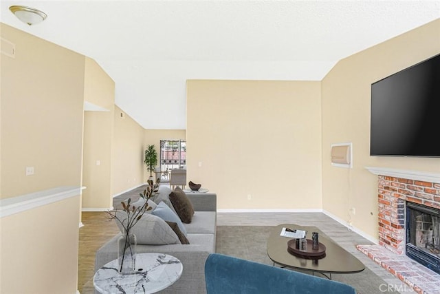 living room with lofted ceiling, hardwood / wood-style floors, and a fireplace