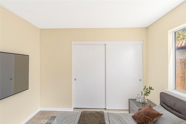 unfurnished room with a textured ceiling and light wood-type flooring