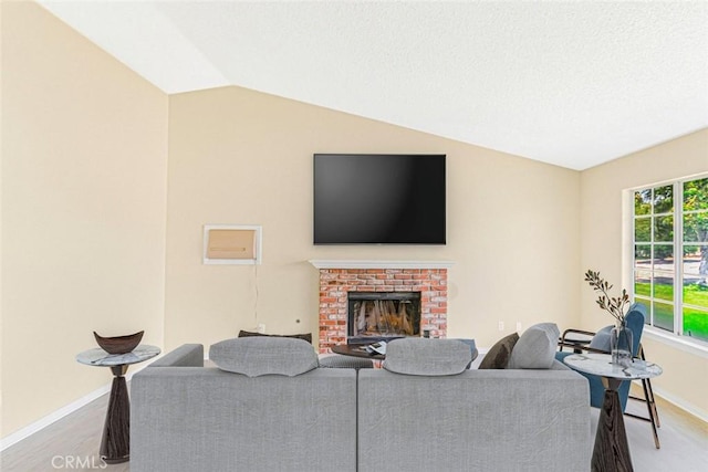 living room with lofted ceiling, a brick fireplace, and hardwood / wood-style flooring