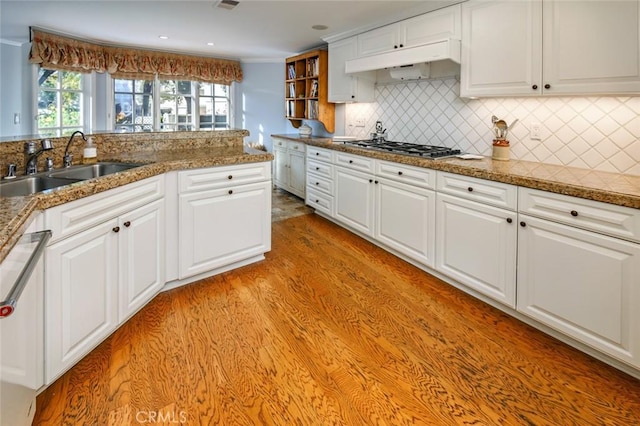 kitchen with sink, white cabinetry, dishwasher, light hardwood / wood-style floors, and decorative backsplash