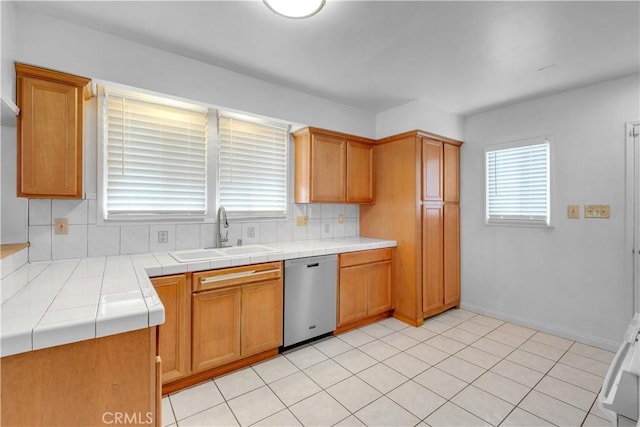 kitchen featuring sink, backsplash, tile counters, and dishwasher