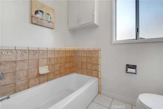 bathroom featuring a washtub, tile patterned floors, and toilet