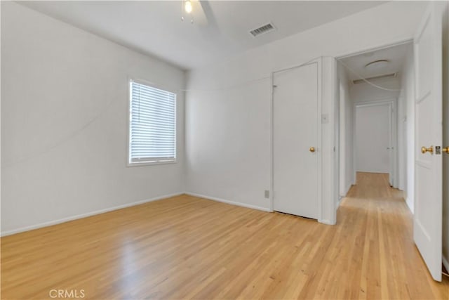 empty room with ceiling fan and light hardwood / wood-style flooring