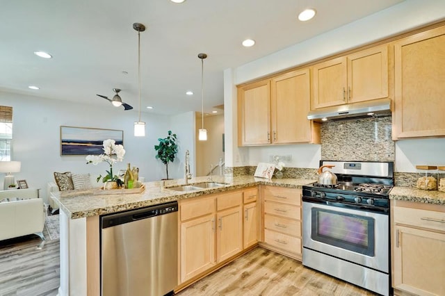 kitchen with appliances with stainless steel finishes, pendant lighting, light brown cabinetry, sink, and kitchen peninsula