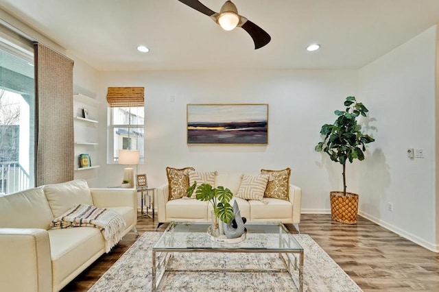 living room featuring hardwood / wood-style floors and ceiling fan