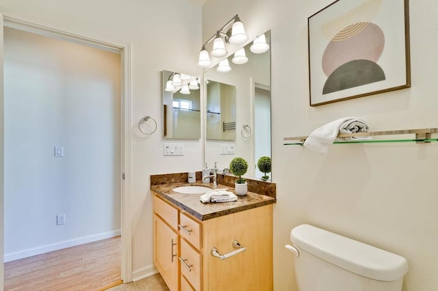 bathroom with hardwood / wood-style flooring, vanity, and toilet