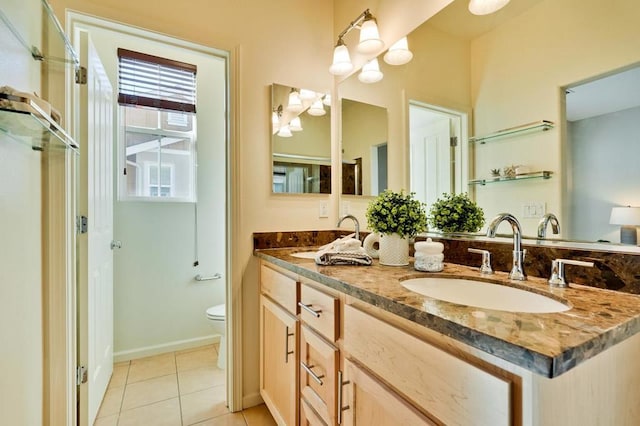 bathroom featuring vanity, tile patterned floors, and toilet