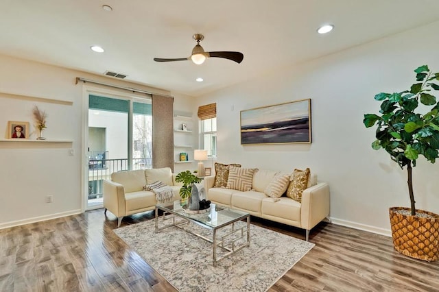 living room with wood-type flooring and ceiling fan