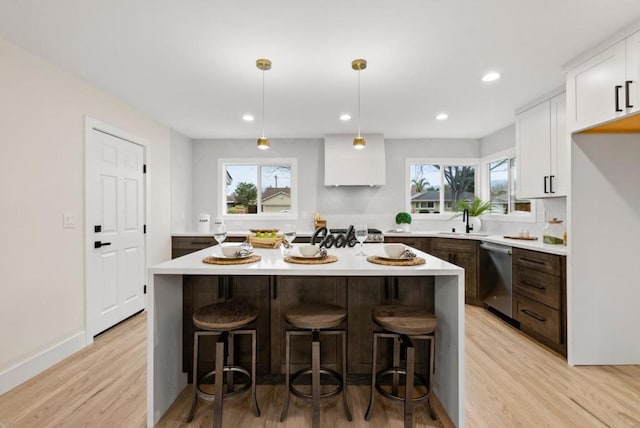 kitchen with white cabinetry, dishwasher, and a center island