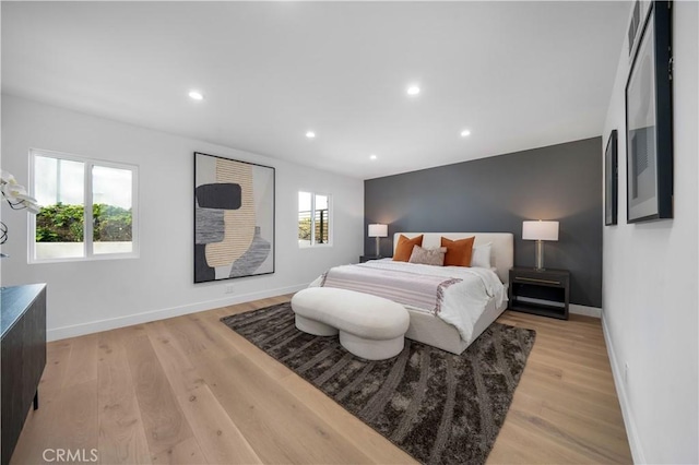 bedroom with multiple windows and light hardwood / wood-style floors