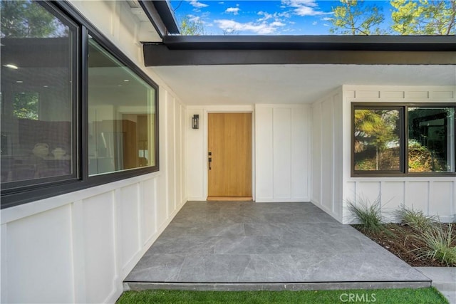 view of exterior entry with a patio