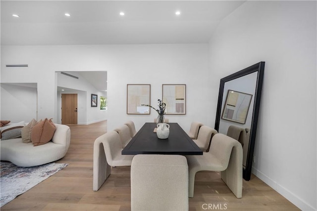 dining space featuring lofted ceiling and light wood-type flooring