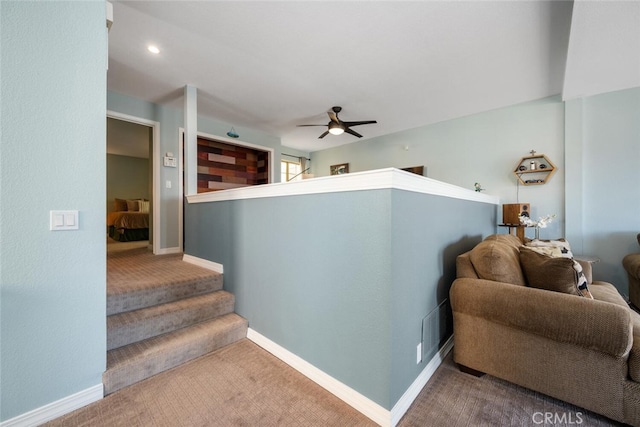 stairs featuring ceiling fan and carpet flooring