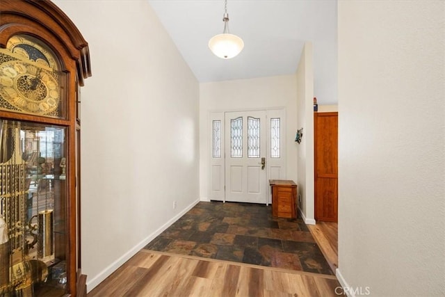 foyer entrance with lofted ceiling and dark hardwood / wood-style flooring