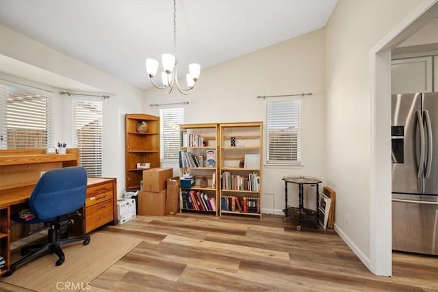 office area featuring vaulted ceiling, a chandelier, and light hardwood / wood-style floors