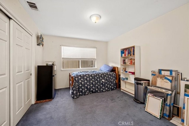 carpeted bedroom with stainless steel fridge and a closet