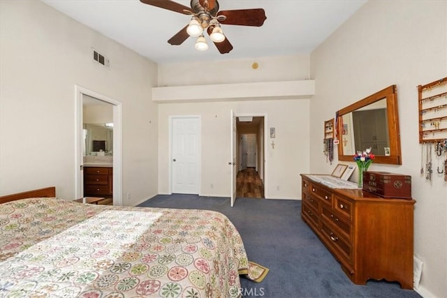 bedroom featuring ceiling fan, dark carpet, and ensuite bath