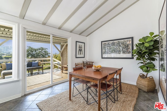 dining space featuring lofted ceiling with beams