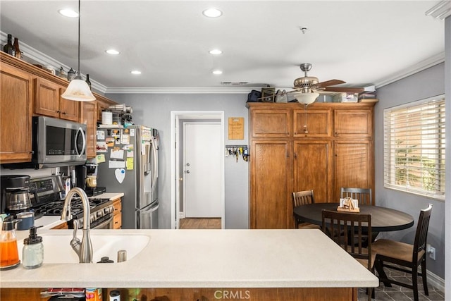 kitchen featuring crown molding, ceiling fan, appliances with stainless steel finishes, decorative light fixtures, and kitchen peninsula