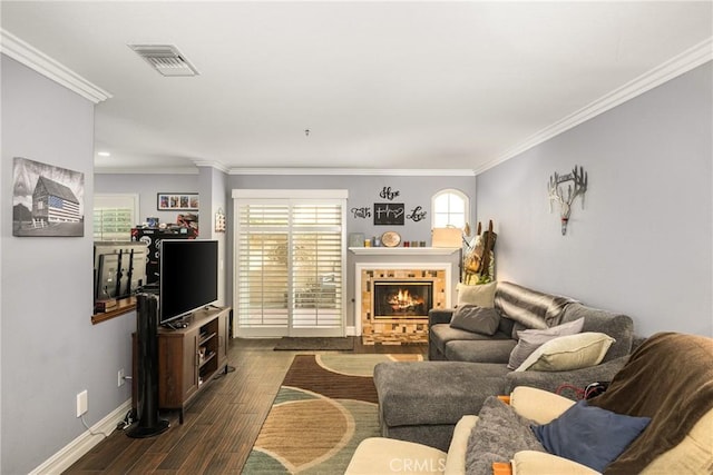 living room with ornamental molding, dark wood-type flooring, and a tile fireplace