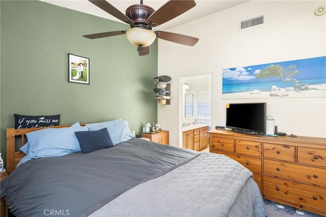 bedroom with ceiling fan, ensuite bath, and carpet