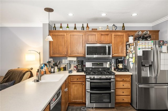 kitchen featuring pendant lighting, sink, ornamental molding, and appliances with stainless steel finishes