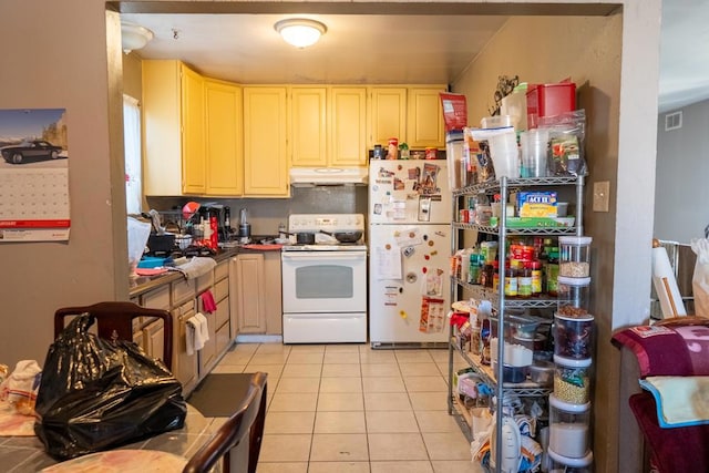 kitchen with white appliances, light brown cabinetry, and light tile patterned floors